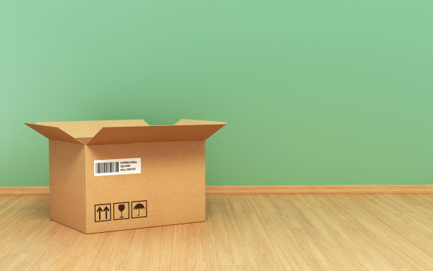 纸板箱在木地板前，绿色墙壁stock photo图片下载
