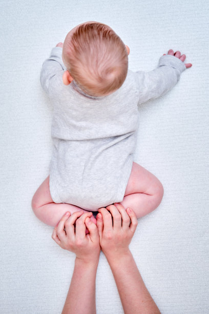 妈妈用女性的双手教婴儿蹒跚学步的婴儿爬行图片下载