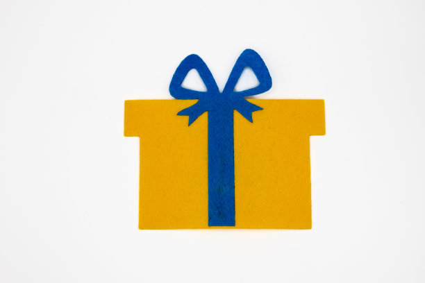 手工制作的圣诞玩具，以黄色礼品盒的形式，上面有蓝色的丝带图片下载