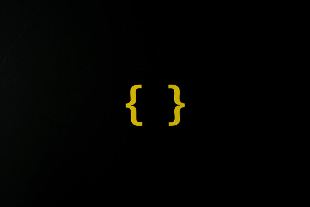 黄色木制符号“括号”在黑色背景上图片下载