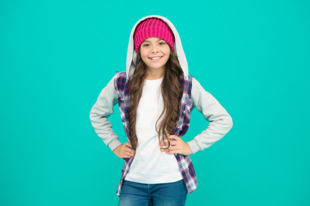 微笑的时装模特戴着耳机听音乐。儿童休闲风格。放松的时间。小孩长发无线耳机。快乐的童年。快乐的嬉皮士女孩绿松石背景图片下载