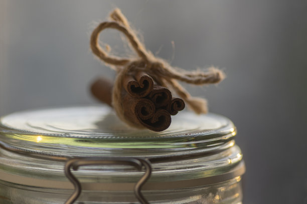 新鲜的生肉桂棒在玻璃剂量瓶，棒与一个黄麻天然缠绕图片下载