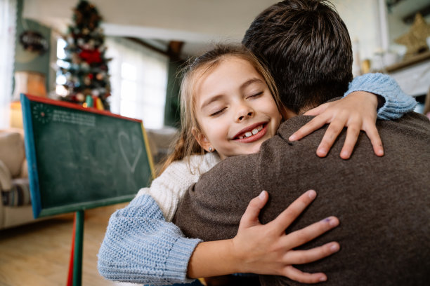 全家快乐，父亲节快乐。父亲和女儿拥抱在一起玩得很开心图片下载