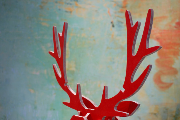 用纸板拼成一对红麋鹿的鹿角来庆祝圣诞节。这张照片的背景是一团混合绿色的散景。作为圣诞主题的背景很理想。驼鹿的轮廓概念。图片下载