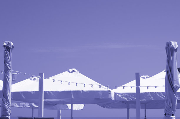 户外咖啡馆配有开闭的大伞、带灯的花环，天空和复制空间的色彩十分浓郁图片下载