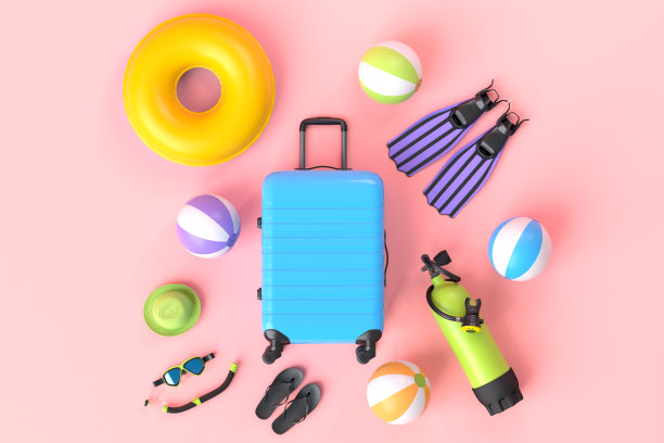 彩色手提箱或行李与海滩配件在粉红色的背景。图片下载