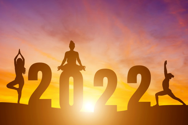 新年快乐数字2022，晨曦中练瑜伽的女子晨曦越过地平线背景，健康和新年快乐的概念。图片下载
