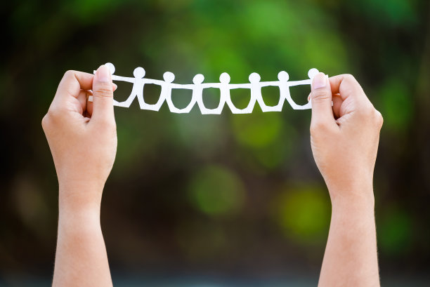 纸链娃娃在绿色的森林背景图片下载