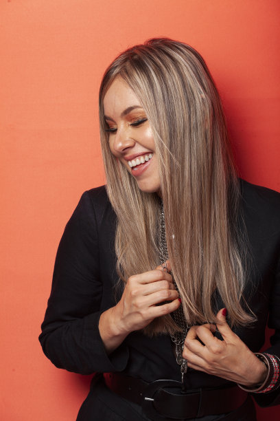 一个女人的肖像在橙色的背景微笑图片下载