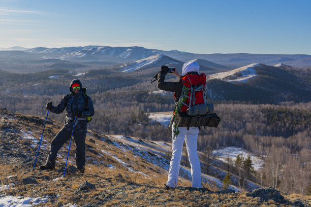 一对中年夫妇在黎明时分去阿尔卑斯山的冬季山区徒步旅行，他们用智能手机拍了一张照片图片下载