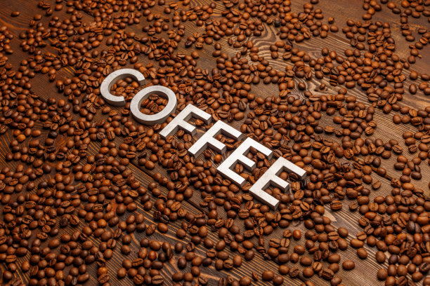 用烤过的咖啡豆做成的木板上印着银色的“咖啡”字样图片下载