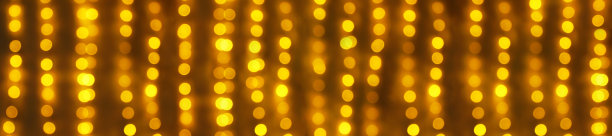 金色的喜庆的旗帜。模糊的橙色节日灯光在黑暗中作为背景图片下载