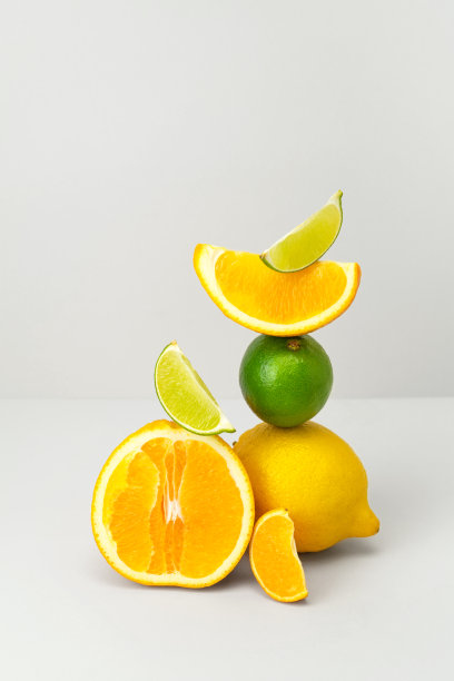 新鲜多汁橙半，柠檬，酸橙，橘子片平衡在灰色背景。早上可以用柑橘类水果做果汁或奶昔。健康饮食营养与维生素c，时髦的柠檬水成分图片下载
