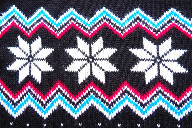 提花针织图案。圣诞节或新年的几何装饰。编织白色雪花，蓝色粉红色之字形在一个黑色的背景。冬季时尚现代蔬菜传统民俗点缀图片下载