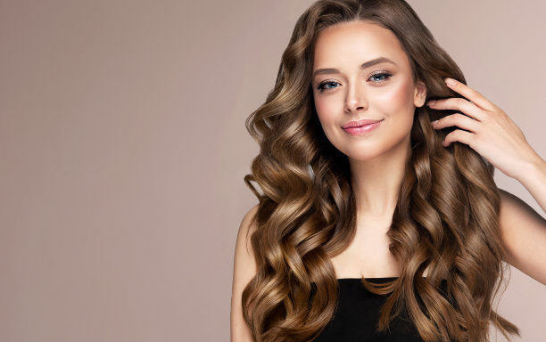 漂亮的微笑在年轻的脸上，棕色头发美丽的模型与长，良好的修剪头发。头发护理和美发艺术。图片下载