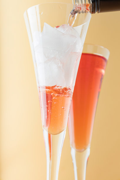 玫瑰葡萄酒倒在米色背景的玻璃杯上。特写镜头图片下载