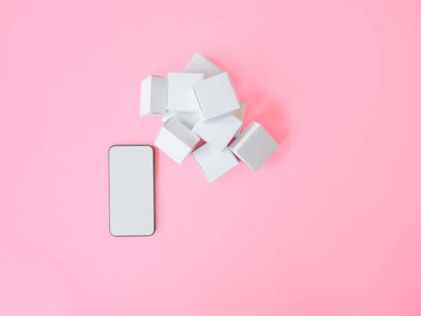 商务电子商务或营销策略概念从智能手机与空白屏幕和产品盒在粉红色的背景。俯视图图片下载
