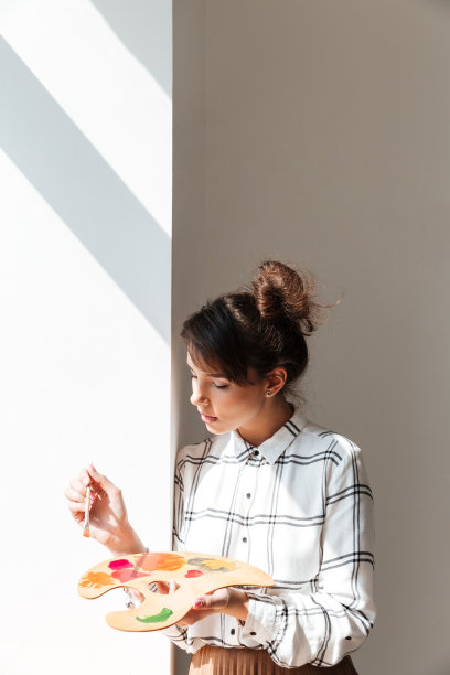 站在工作室里拿着调色板的女艺术家图片下载