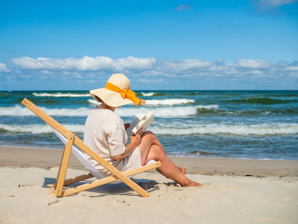 女人放松在海滩看书图片下载