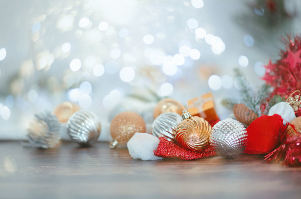 焦点是金色的星星和圣诞球，灯光和圣诞壁炉附近的散景。素材图片