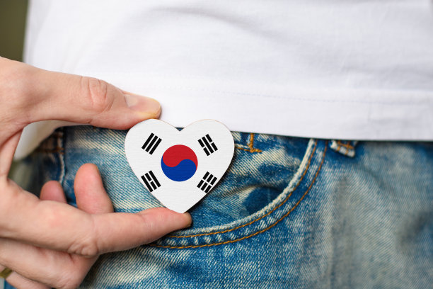 韩国公民。男子手中握有韩国国旗心形图案的木制徽章图片下载