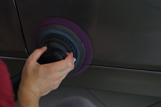 一个男人在擦拭一辆车的车盖，特写的手图片下载