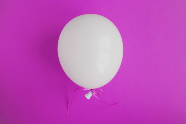 粉色背景中间的白色气球。特写镜头。副本的空间。图片下载