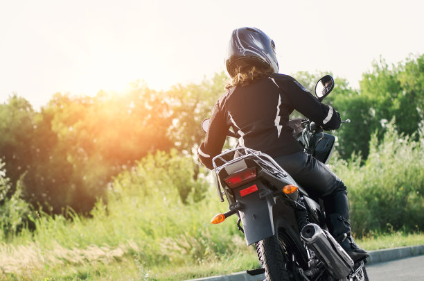 骑摩托车的女孩穿着皮夹克和头盔在摩托车上图片下载