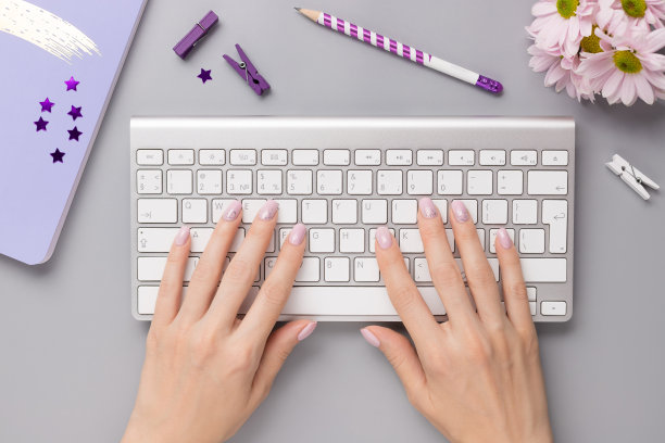 女人用键盘在灰色的桌子上用笔记本，文具图片下载