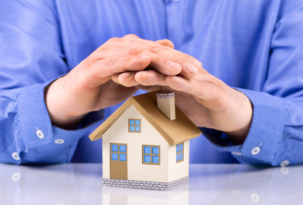 财产保险和安全概念商人手盖房子图片下载