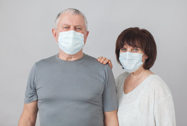 一对在大流行冠状病毒中戴医用口罩的老年人图片下载