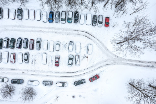 停在积雪覆盖的冬季停车场的汽车。无人机俯瞰照片。图片下载