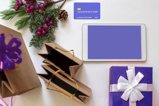 圣诞网上购物概念:数码平板电脑，信用卡，带礼物的紫色盒子，纸袋图片下载