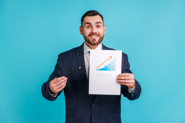满意的留着胡子的商人穿着正式的西装，展示业务增长图，用钢笔和铅笔指着纸质文件图片下载