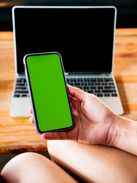 女人拿着智能手机的绿色屏幕，在咖啡厅或咖啡厅喝咖啡。图片下载