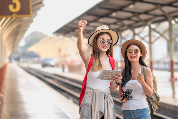 一群朋友旅行者在火车上，在站台上等火车，年轻男女在火车站挥手，旅游生活方式和季节度假概念。图片下载