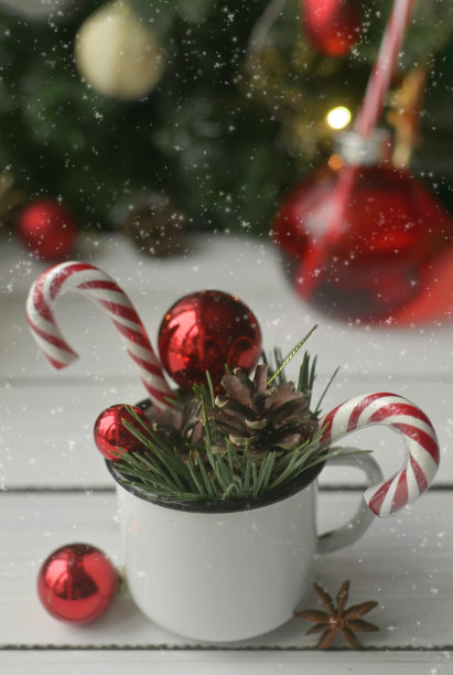 有红色气球、圣诞树树枝和棒棒糖的圣诞杯子。真正的圣诞节照片。为假期做准备。舒适的假期在家。垂直图片下载