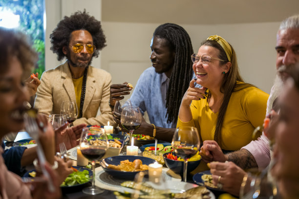 不同年龄和种族的人吃素食晚餐。一群多民族的朋友在温馨的房子里共进晚餐，欢聚一堂，庆祝节日图片下载