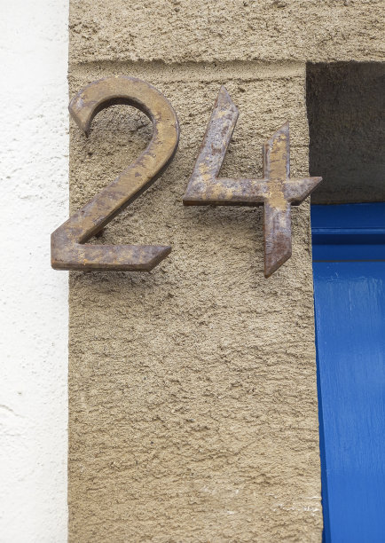 24号房子。生锈的铁盖在棕色水泥门柱上图片下载