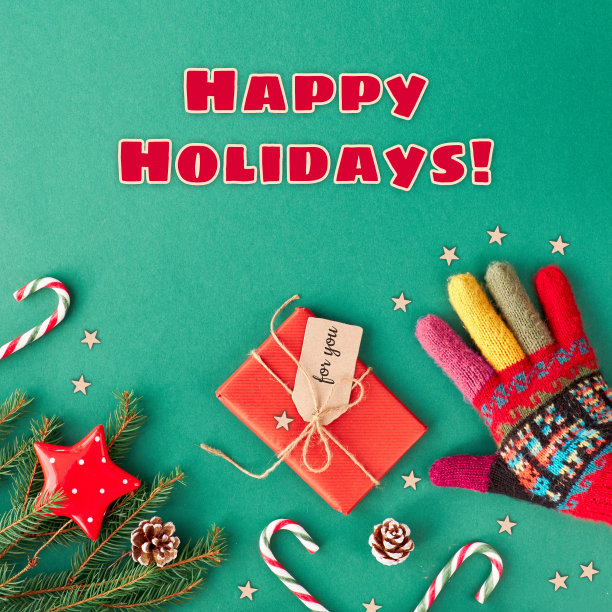 节日快乐文本。创意圣诞平铺背景在绿色和红色的绿色纸与复制空间。手戴华丽的羊毛手套，糖果手杖，用工艺纸标签包装的礼物，星星和杉木树枝图片下载