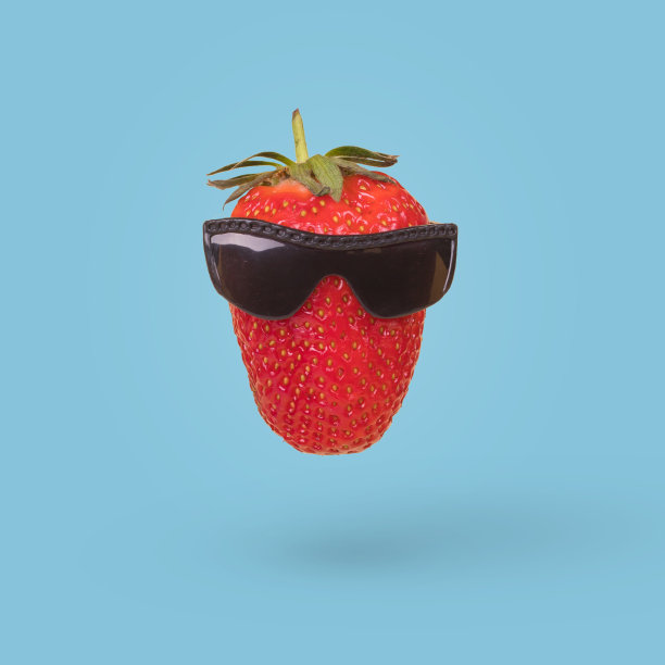 风格化草莓与太阳镜孤立在蓝色的背景。图片下载