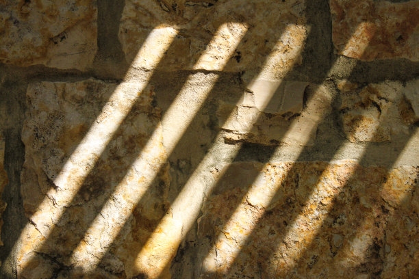 背景-古老粗糙的岩石墙在深阴影与明亮的光斜线条。图片下载