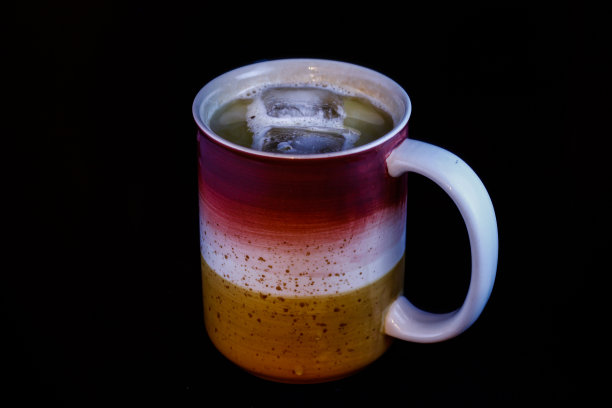 在黑色背景上热气腾腾的咖啡杯图片下载