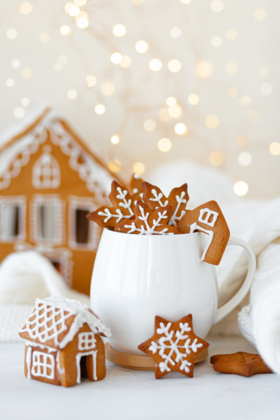圣诞作文与白色杯子热巧克力和姜饼饼干。房子的背景。假日氛围，舒适的手工装饰。圣诞树小彩灯,散景。近距离图片下载