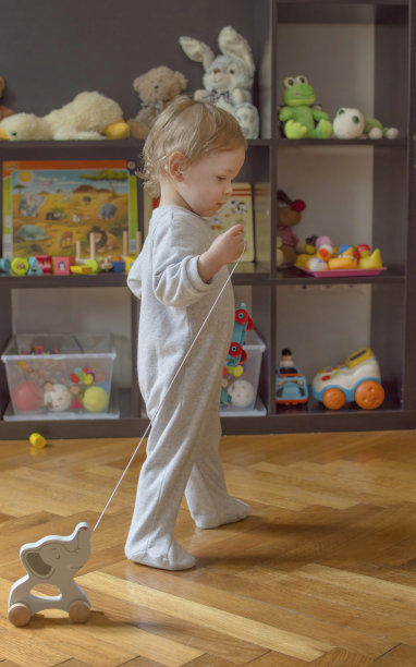 可爱的小男孩在家里玩五颜六色的玩具，在地板上。儿童室内活动图片下载