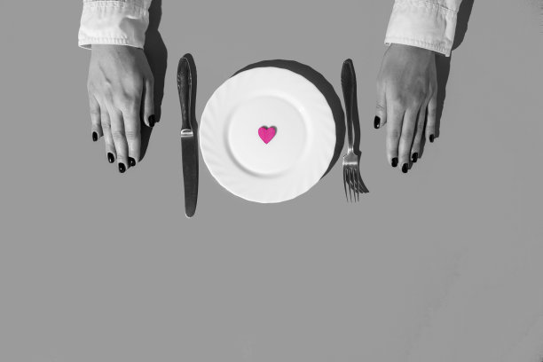 爱在菜单上。盘子里有颗粉色心形的女孩。爱，黑白的最小概念。图片下载