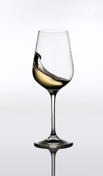 一杯美味的白葡萄酒在运动，飞溅孤立的灰色背景图片下载