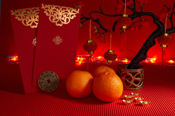 春节节日装饰。橙色，叶子，红色的包，梅花在红色的背景上。素材图片