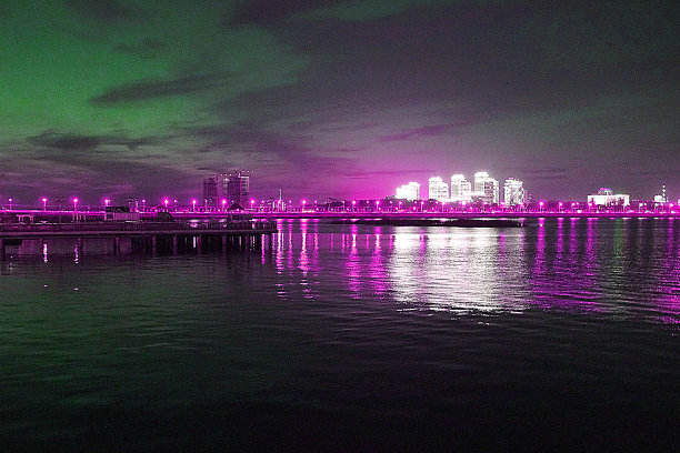 模糊的照片，夜晚的城市灯光倒映在水面上，城市全景图片下载