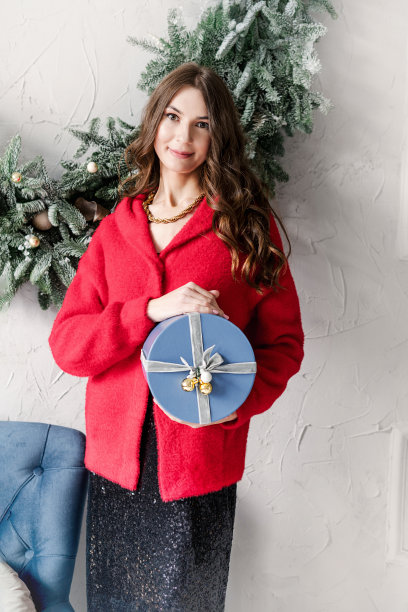 年轻快乐的美女手里捧着礼品盒。圣诞新年快乐，选择性聚焦。图片下载